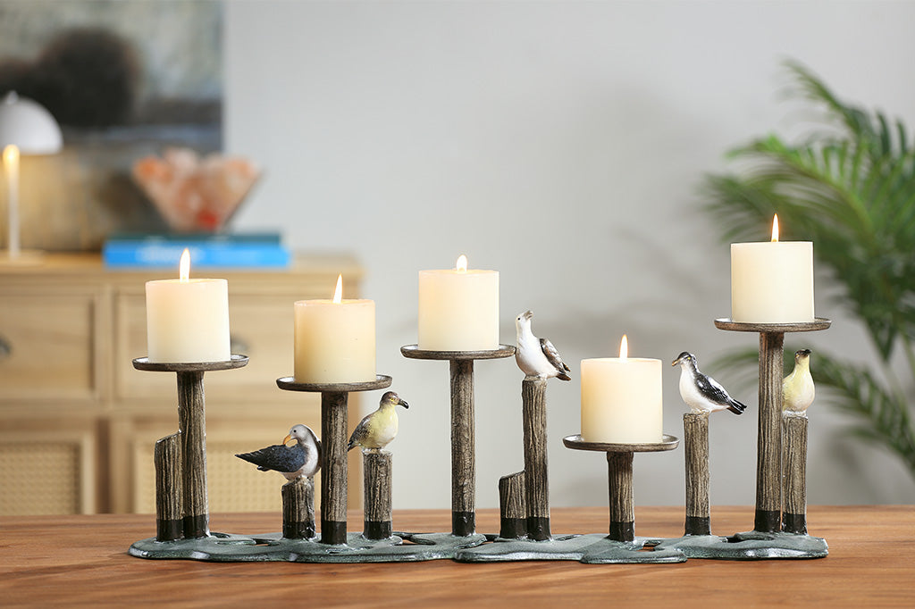 Decorative candle holder with birds on a wooden surface