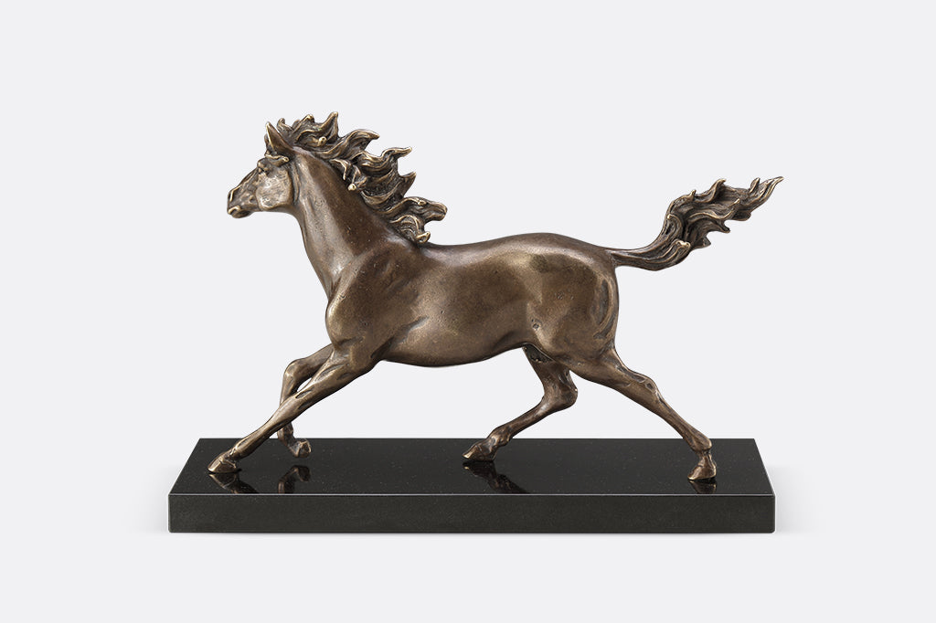 Brass sculpture of a horse running on a marble base.