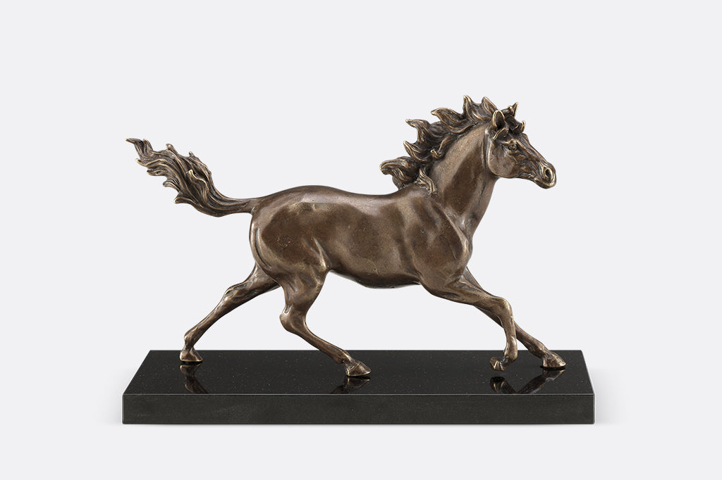 Brass sculpture of a horse running on a marble base.