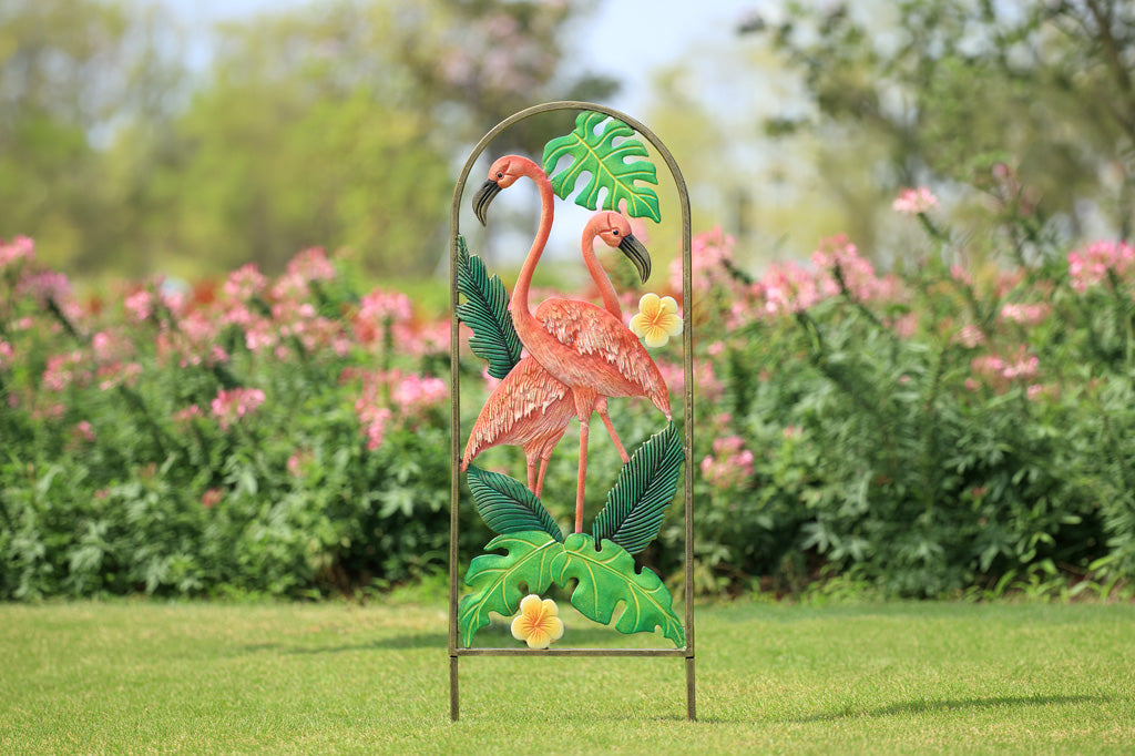 Decorative metal garden art with flamingo design in a garden setting