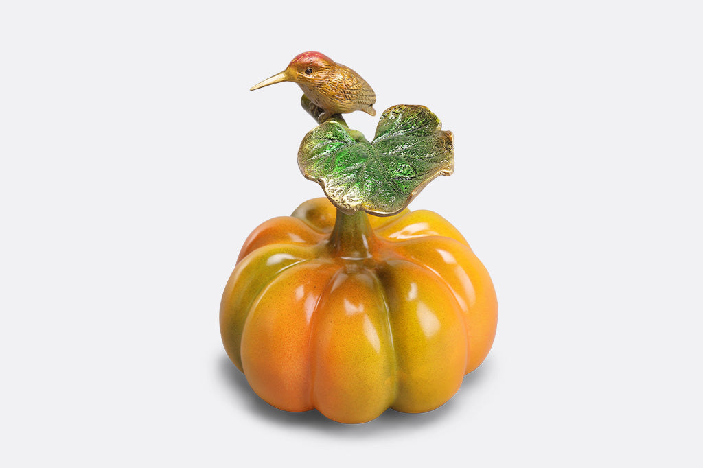 Decorative figurine of a bird on a pumpkin with a white background