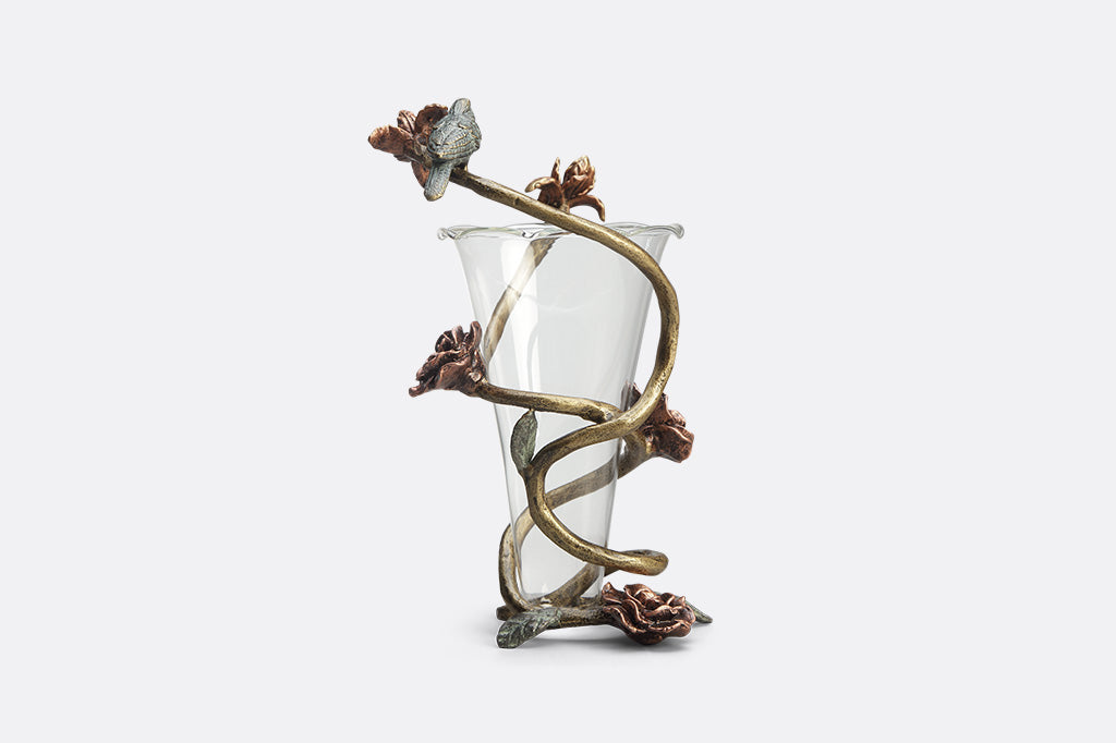 Rose inside glass vase with aluminum flower like detail surrounding vase with small bird sculpture attached 