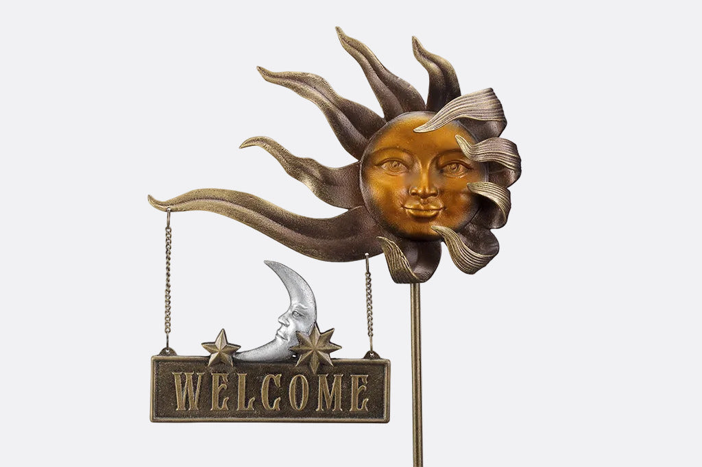 Close up shot of a decorative garden stake with sun face and 'Welcome' sign on a white background