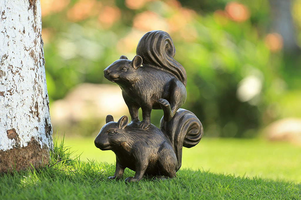 A sculpture of two squirrels playing leapfrog and hopping over each other.