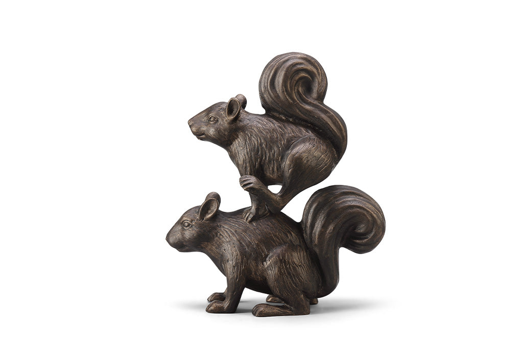 A sculpture of two squirrels playing leapfrog and hopping over each other.