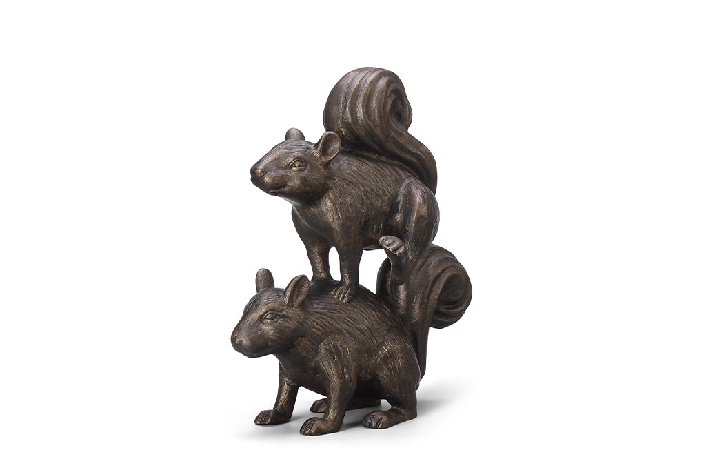 A sculpture of two squirrels playing leapfrog and hopping over each other.