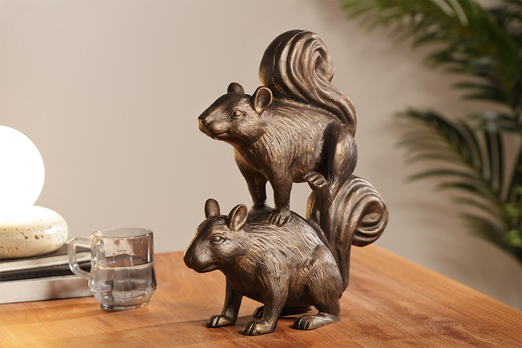 A sculpture of two squirrels playing leapfrog and hopping over each other.