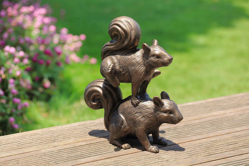 A sculpture of two squirrels playing leapfrog and hopping over each other.