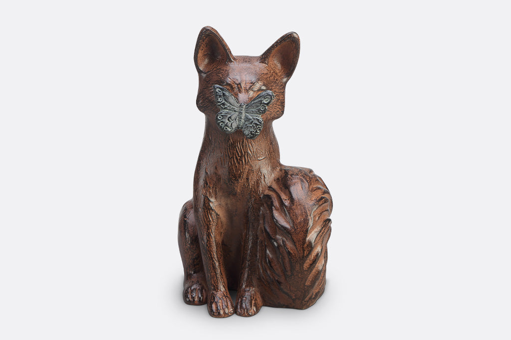 A sculpture of a blue butterfly landing on the nose of a fox.