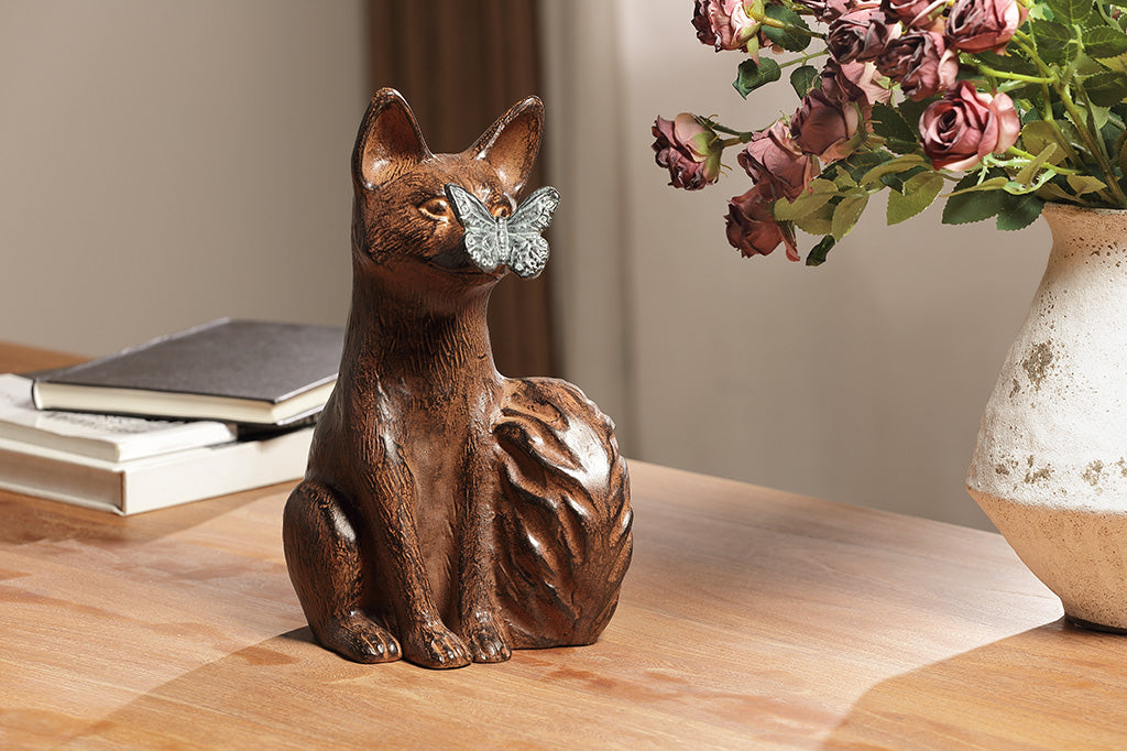 A sculpture of a blue butterfly landing on the nose of a fox.