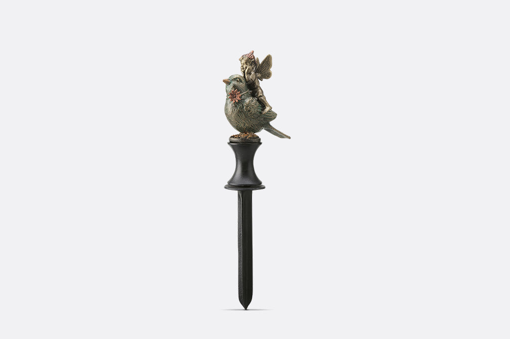 Decorative garden stake with bird and fairy figurines on a white background