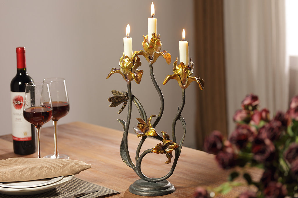 A taper candleholder shaped like Iris flowers with a dragonfly.