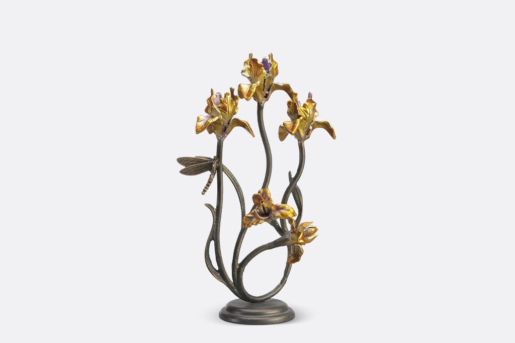 A taper candleholder shaped like Iris flowers with a dragonfly.