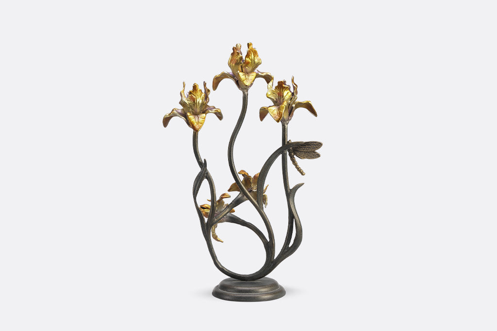 A taper candleholder shaped like Iris flowers with a dragonfly.
