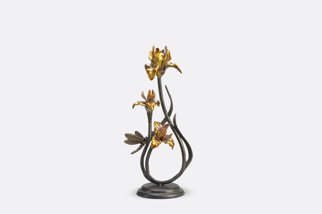 A pair of taper candleholders shaped like iris flowers with a dragonfly.