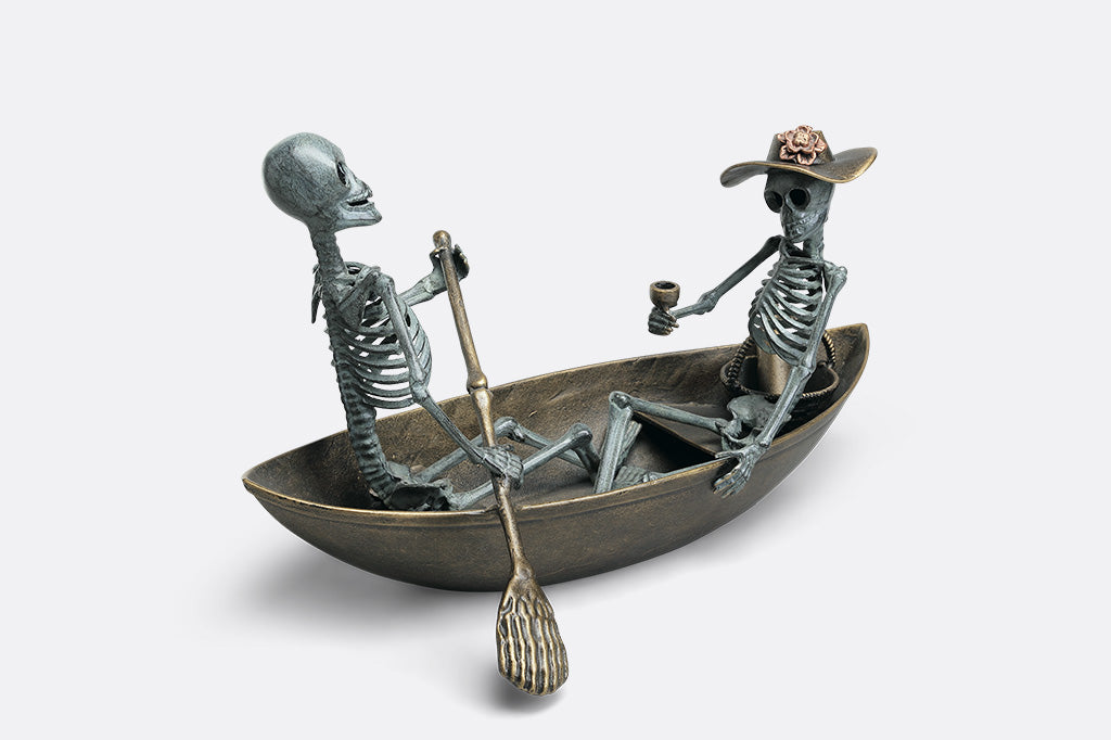Two skeletons in a boat on a white background