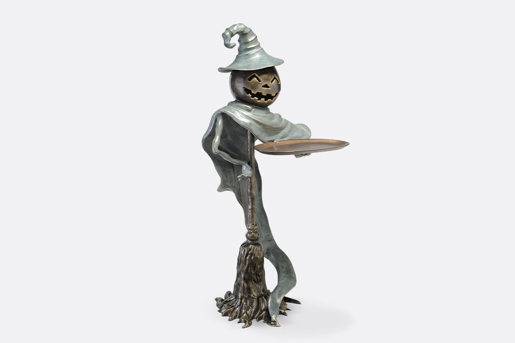 Metallic scarecrow figurine on a white background