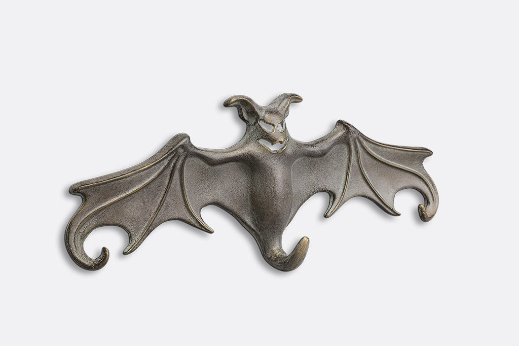 Metallic bat-shaped hook on a white background