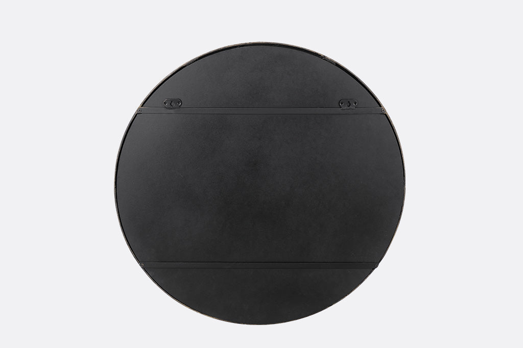 A round mirror with details of Santa and his sleigh being pulled by reindeer across a sky of stars and over rooftops.