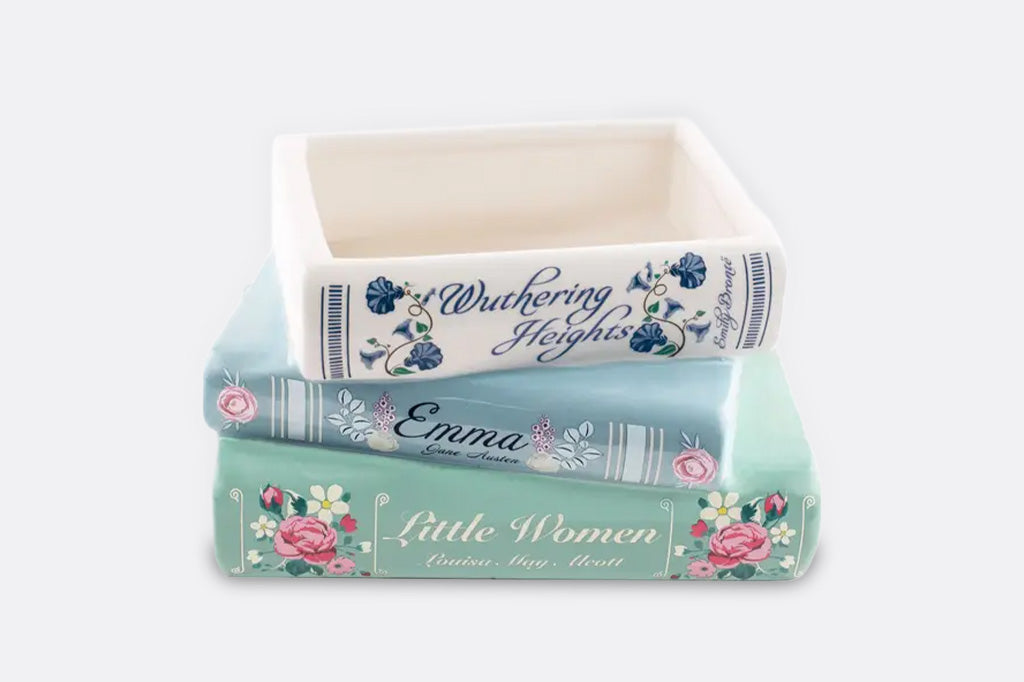 A planter shaped like a stack of three books, Wuthering Heights, Emma, and Little Women.