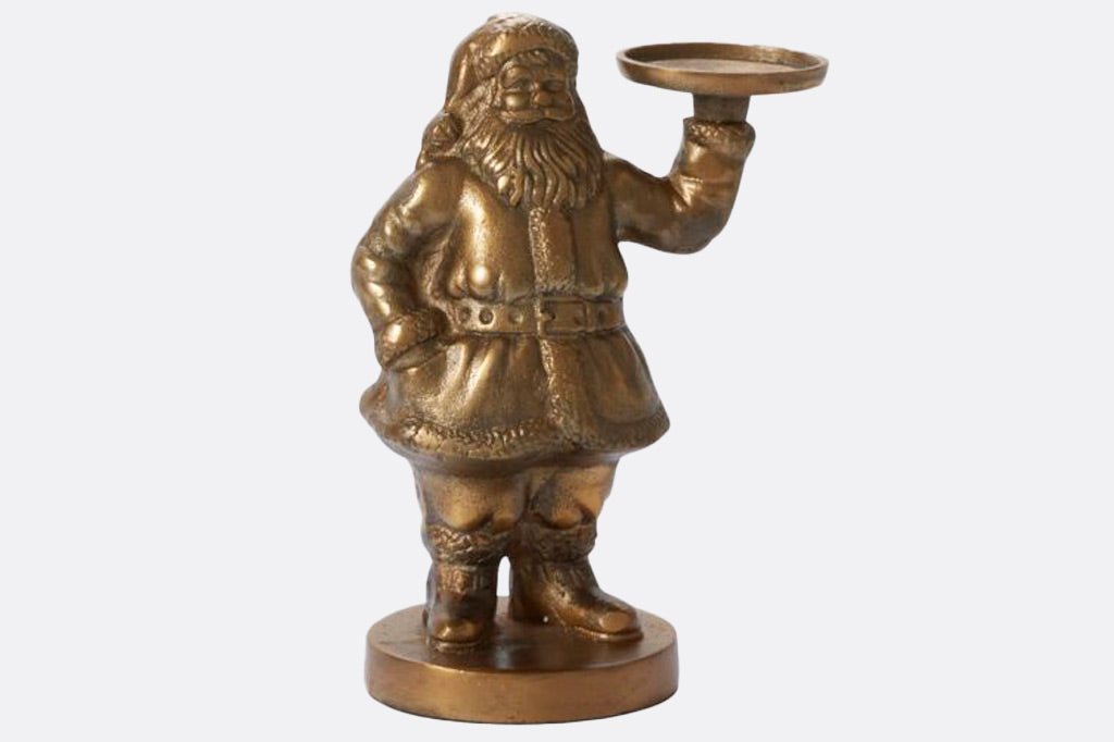 Metal sculpture of Santa holding a votive candle stand