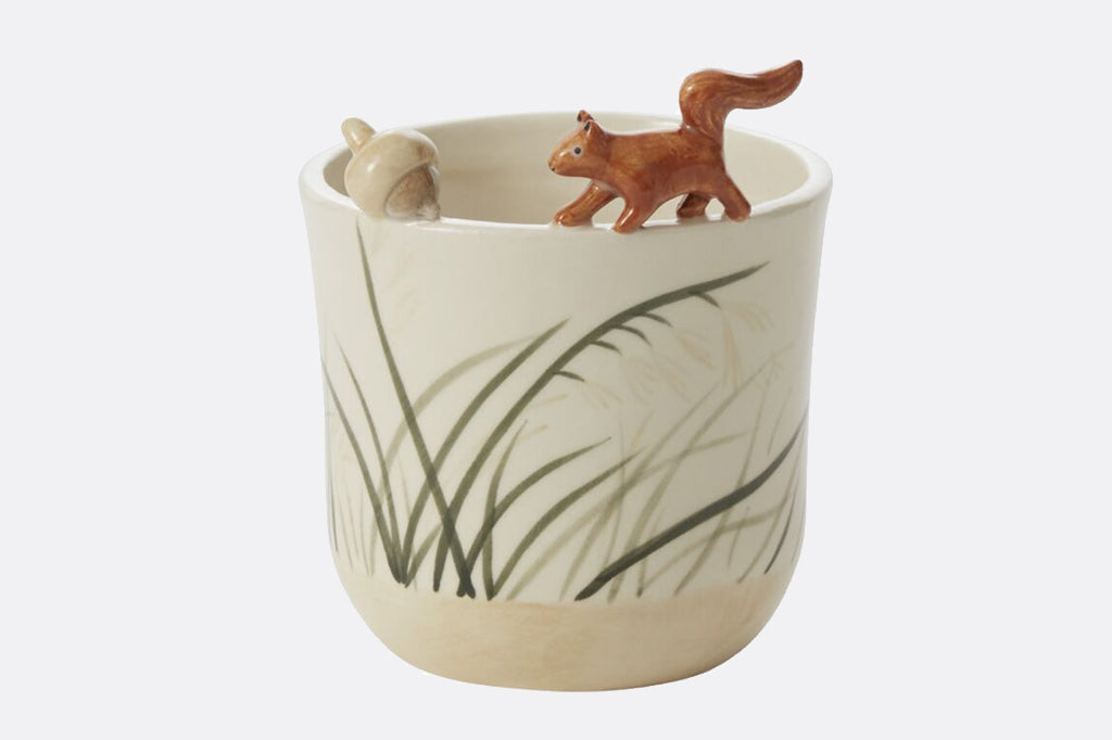 ceramic pot with sculpted squirrel and nut on the rim