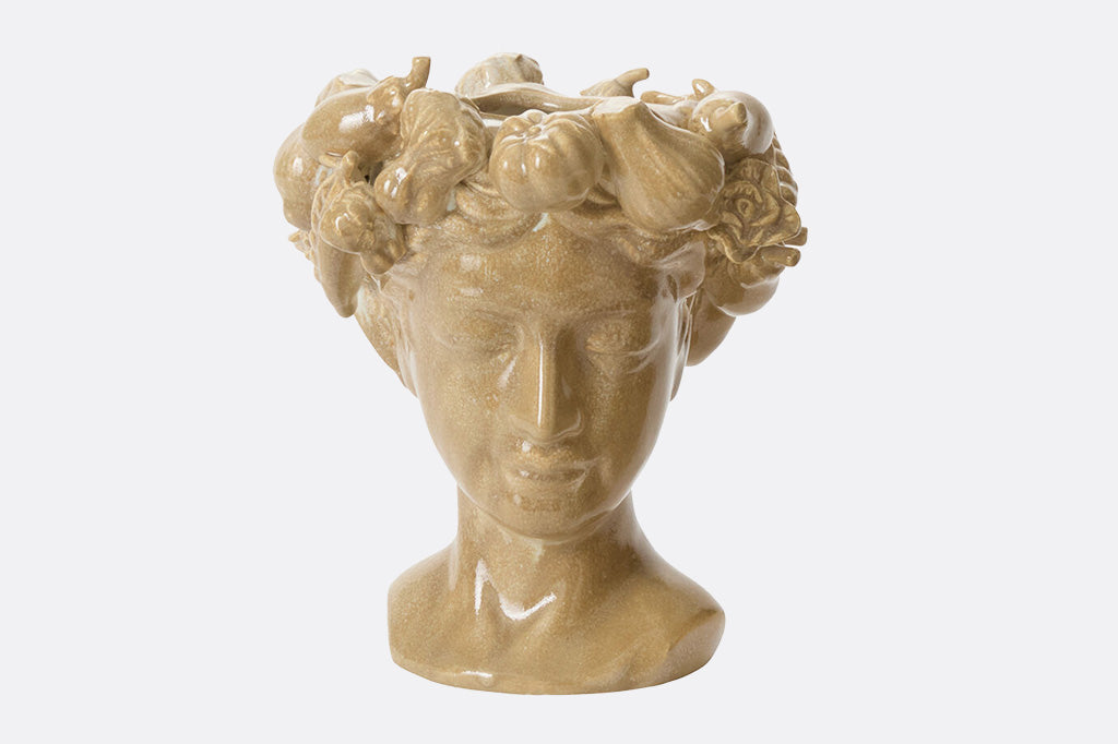 Ceramic bust  with floral and fruit wreath is a vase on a white background