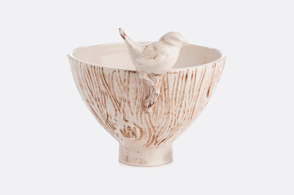 Ceramic bowl from Italy with textured design of tree trunk and bird on rim on a white background