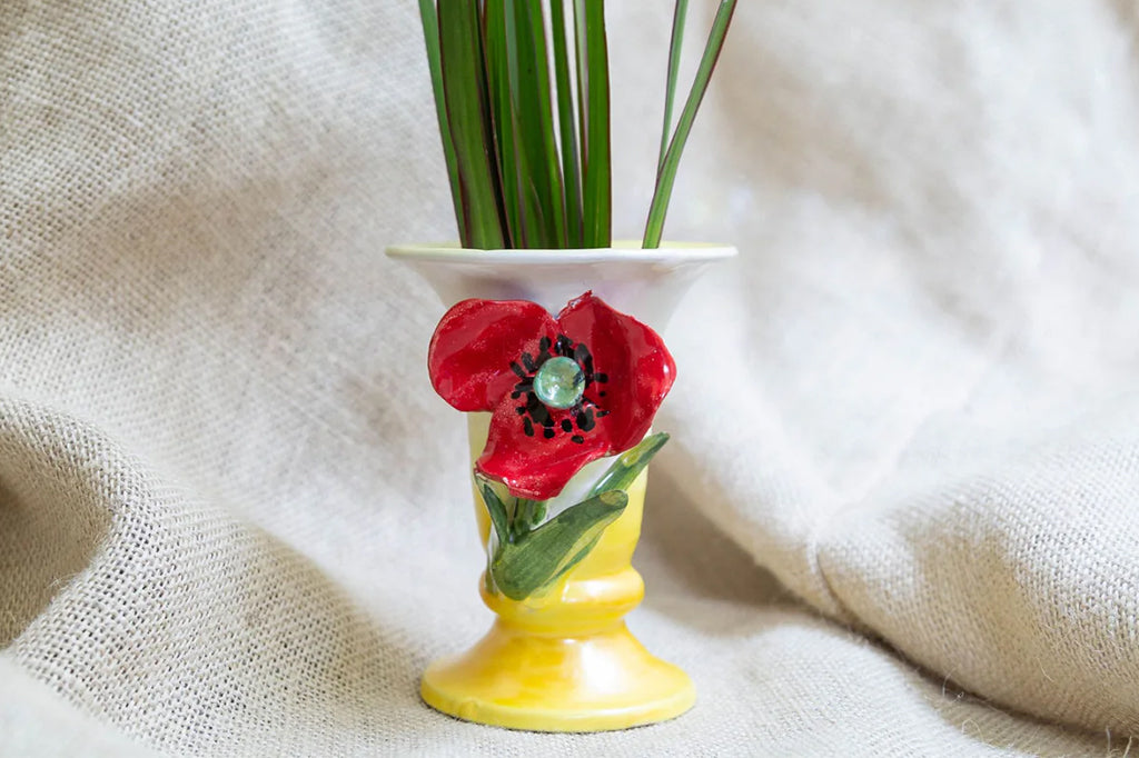 ceramic vase with accent red poppy on front with ornamental grass inside vessel. color of vase Ombre yellow to cream 