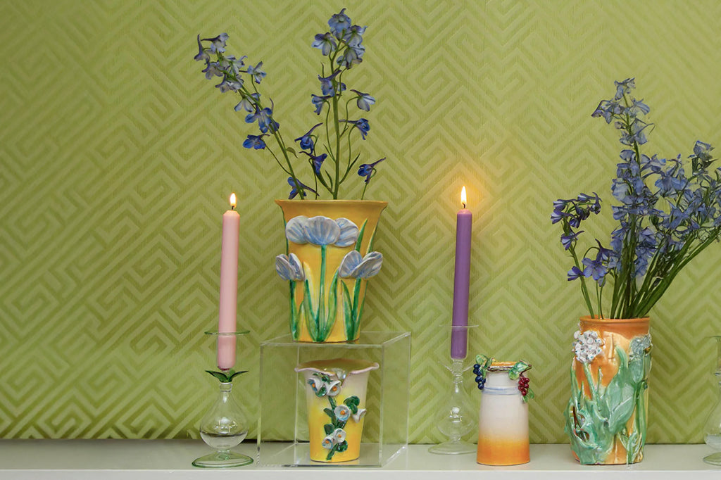 blue 3-d sculpture flowers on mango colored wide neck ceramic vase 