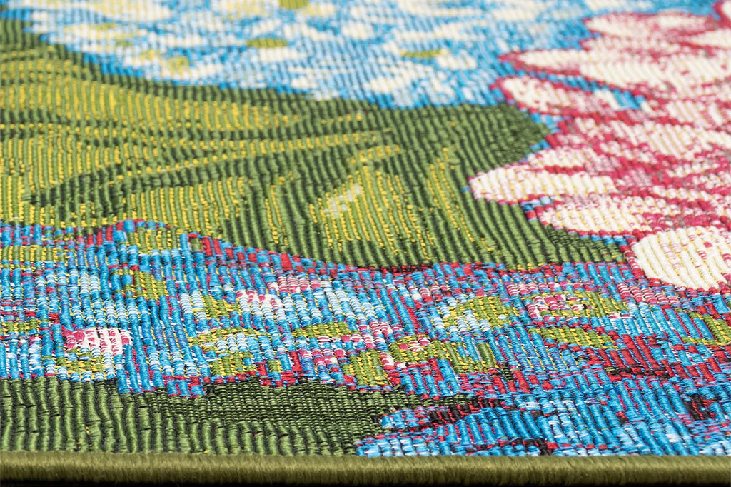 A rug with floral patterns featuring blue, pink, and white hydrangeas and green leaves.