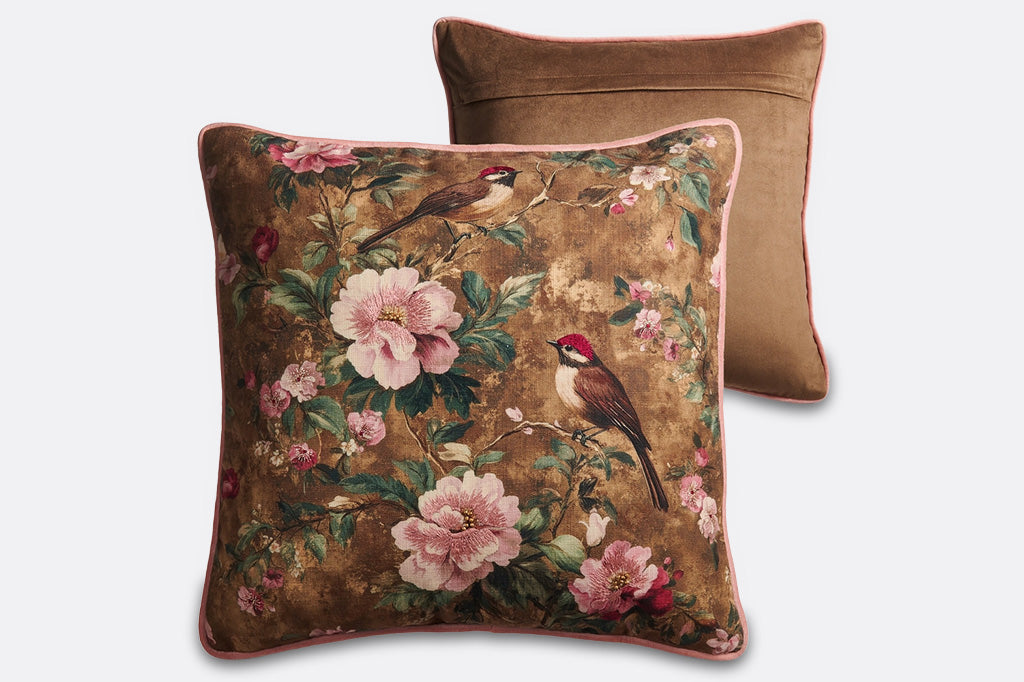 A brown pillow with pink flowers and finches.