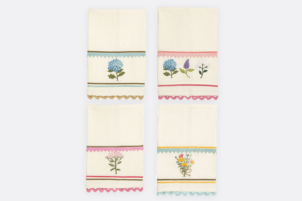 A set of four cotton dishtowels featuring spring flowers in vibrant pastel colors.