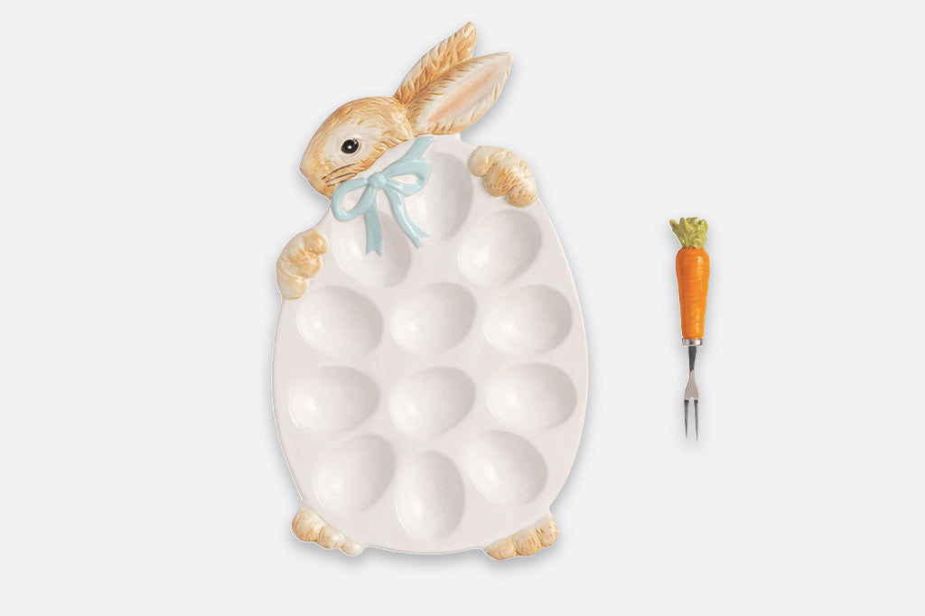 Decorative plate with a rabbit design holding an egg and a carrot fork.