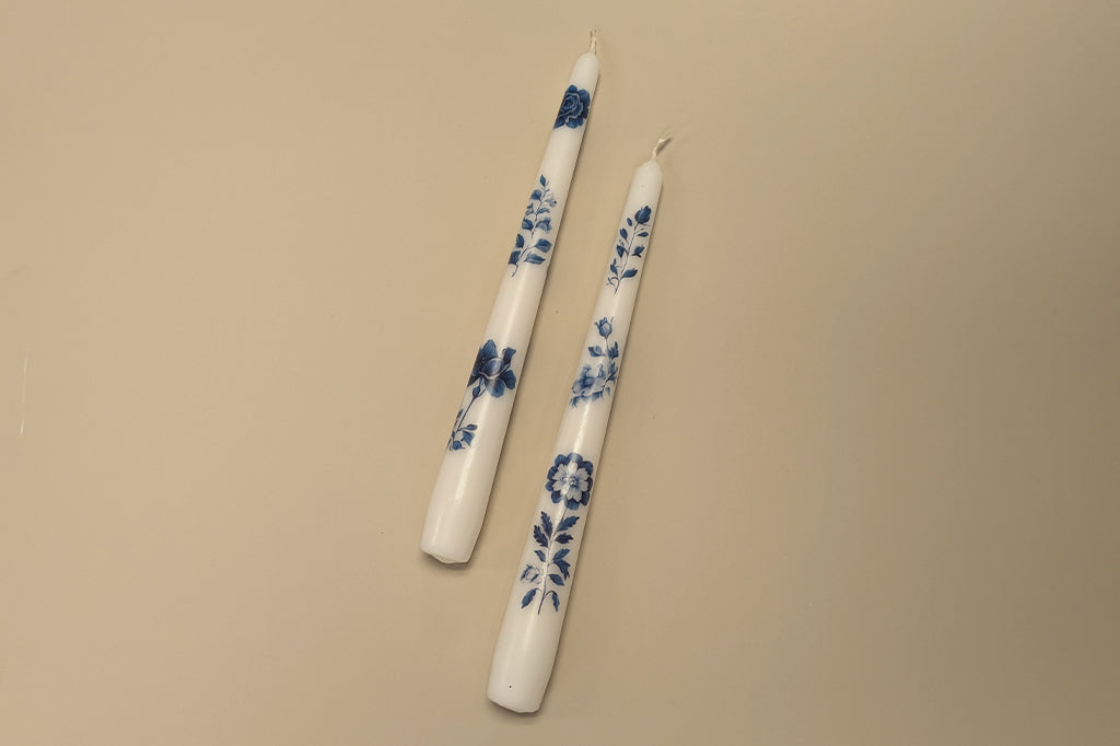 white and blue floral pattern taper candles on mocha background