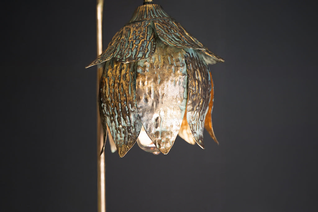 detailed view of metal finish of lamp. Bronze coloring with blue patina highlights