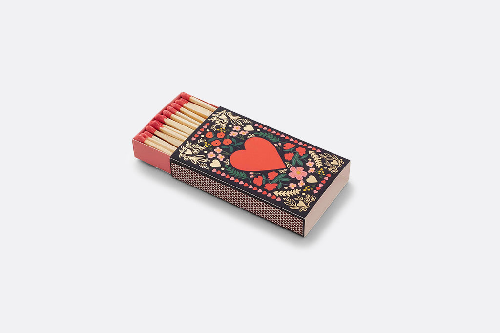 Matchbox with floral design and red heart on a white background