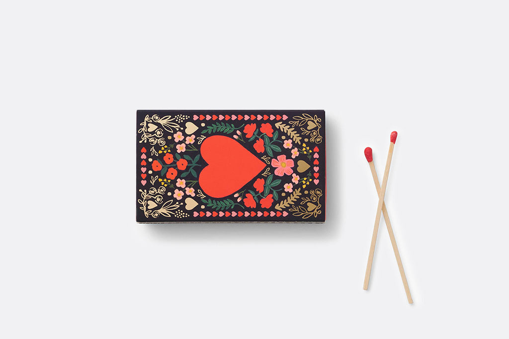 Matches with decorative box featuring a red heart and floral patterns on a white background