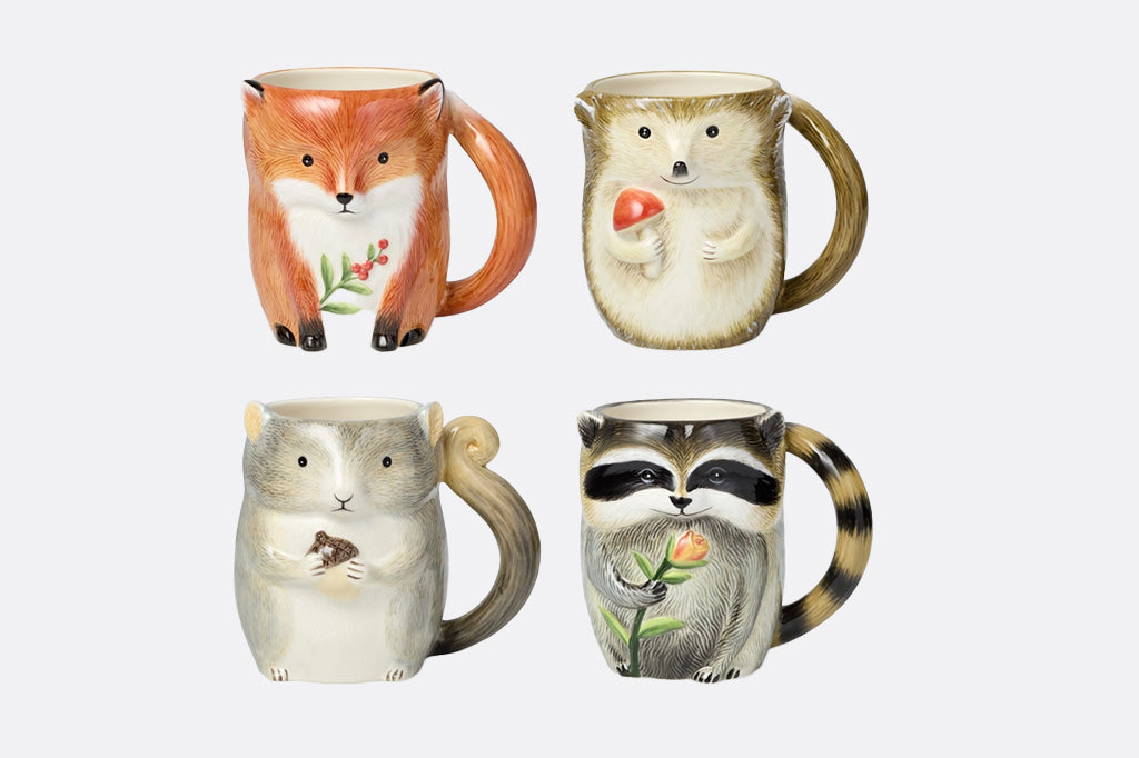 Four animal-themed mugs on a white background: fox, hedgehog, squirrel, raccoon