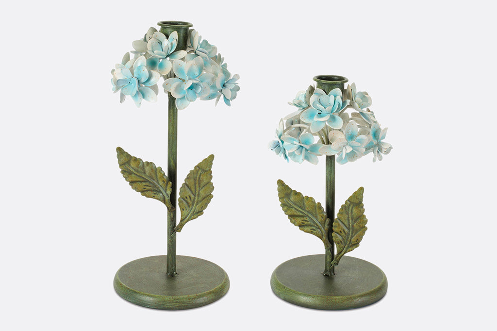 Two taper candleholders shaped like hydrangea flowers.