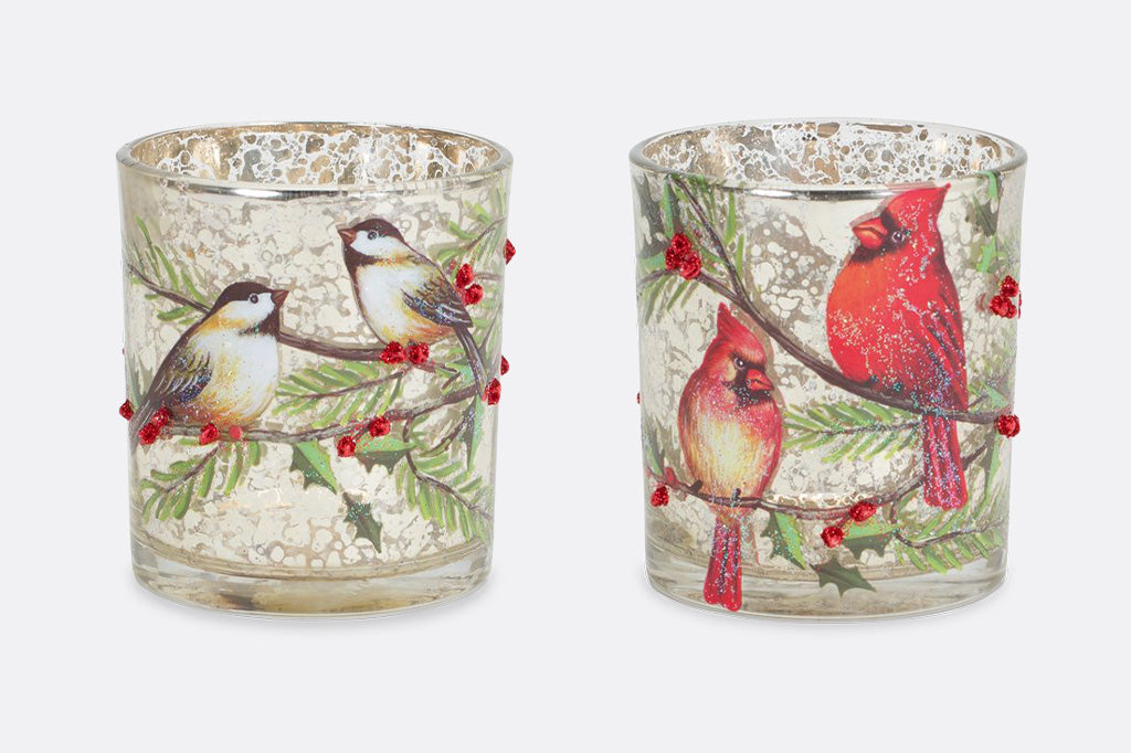 two gold speckled cylindrical cup like candleholders with christmas birds pictured on both, within the branches and mistletoe beaded features pictured on light grey background