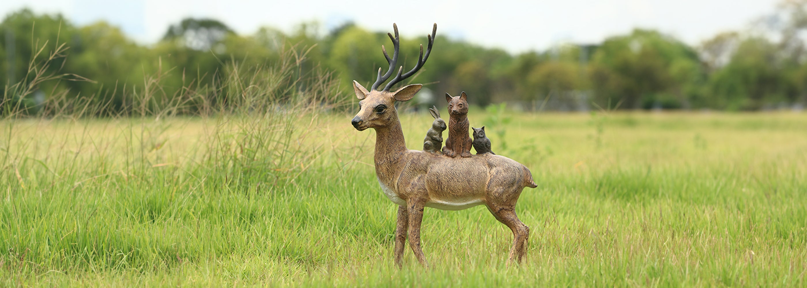 deer sculpture shown in field at sunset