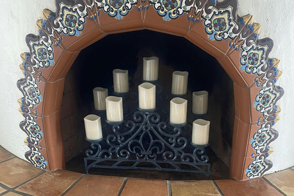 Fireplace with mexican tile border shown with Fleur-de-lys Candelabra inside, holding 10 LED candles