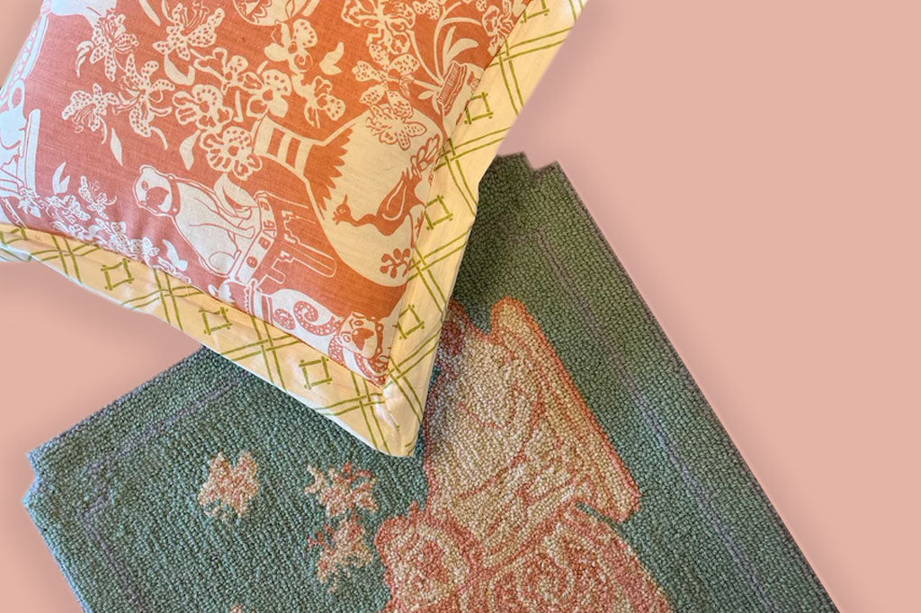 close up of pastel pink and green chinoiserie style pillow shows print of dogs and vases