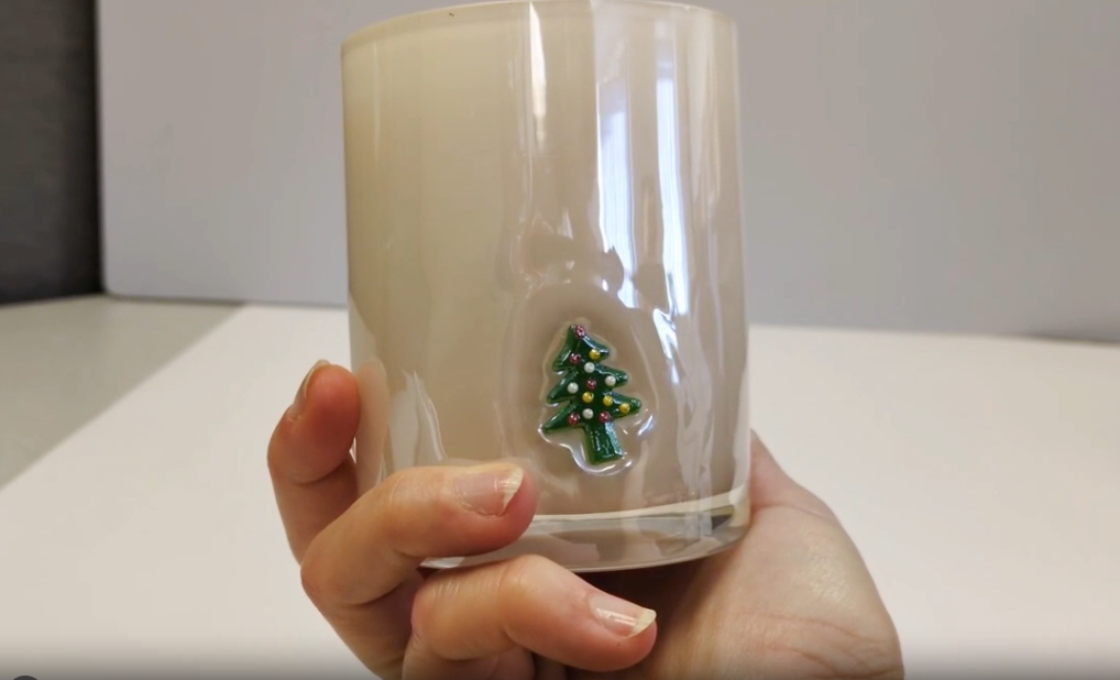 hand holds and rotates a christmas theme candle