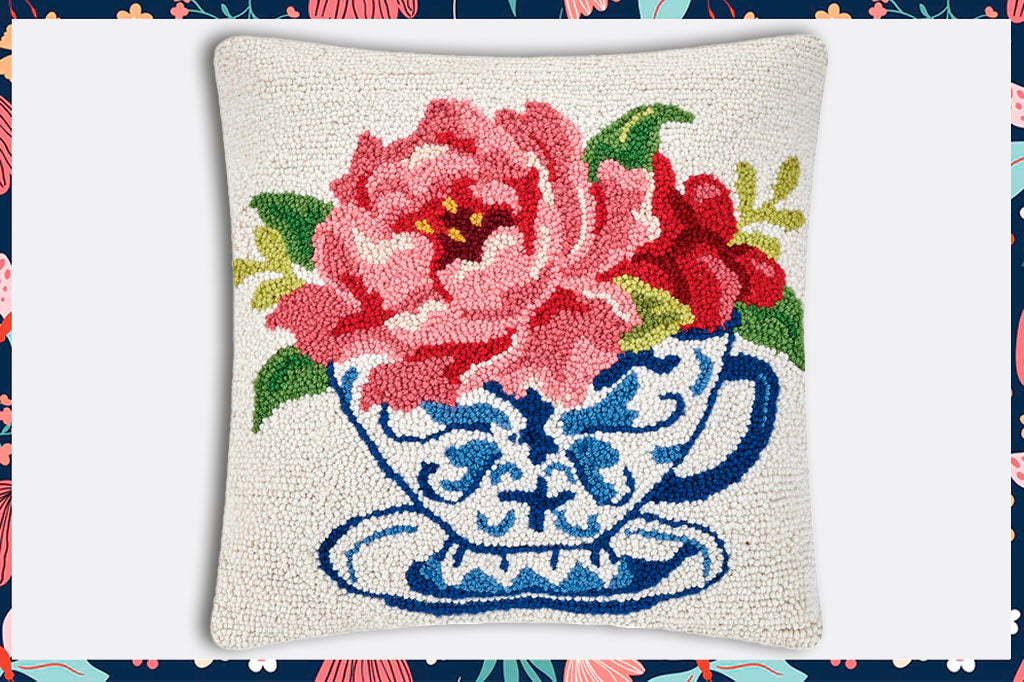 hooked wool pillow showing teacup with pink rose and greens in it