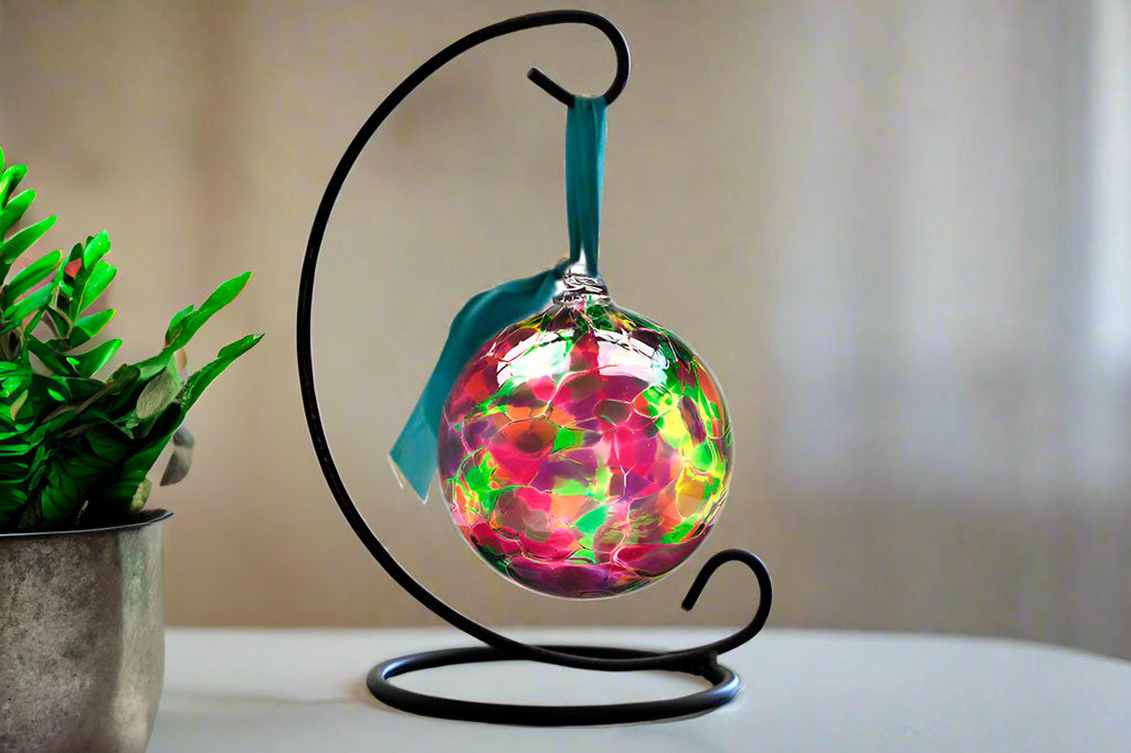 Handblown glass ornament designed to hang from metal stand