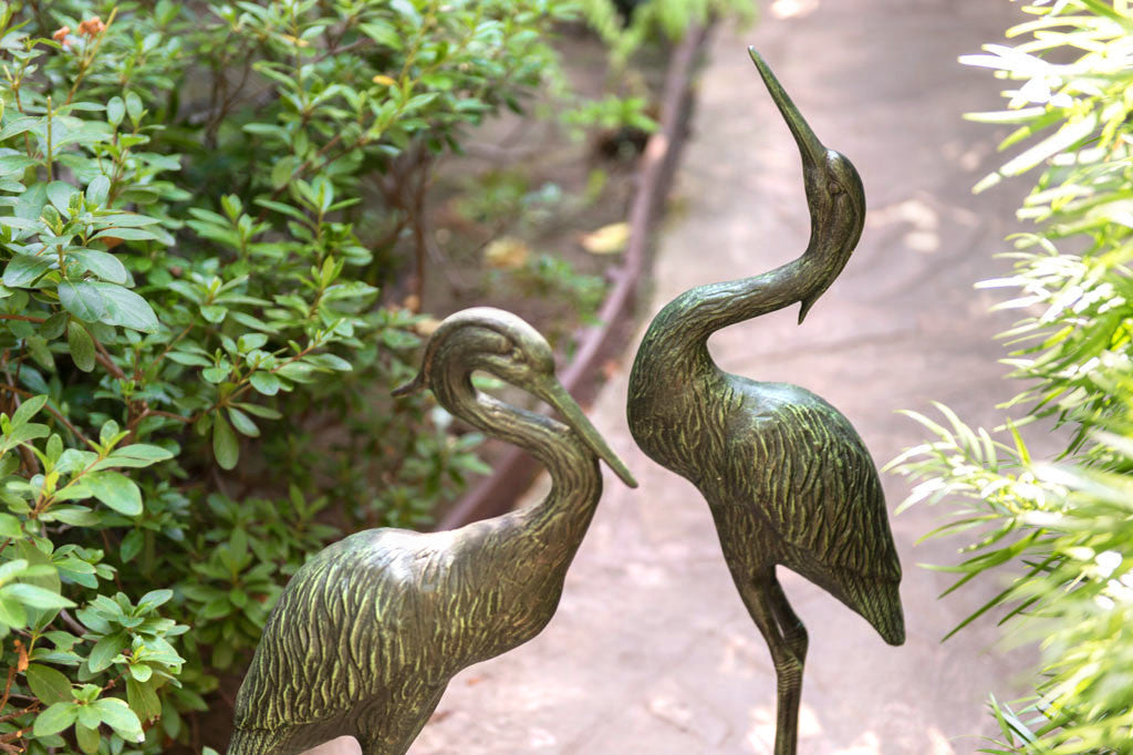 Garden close up view of Heron Pair sculpture on garden path