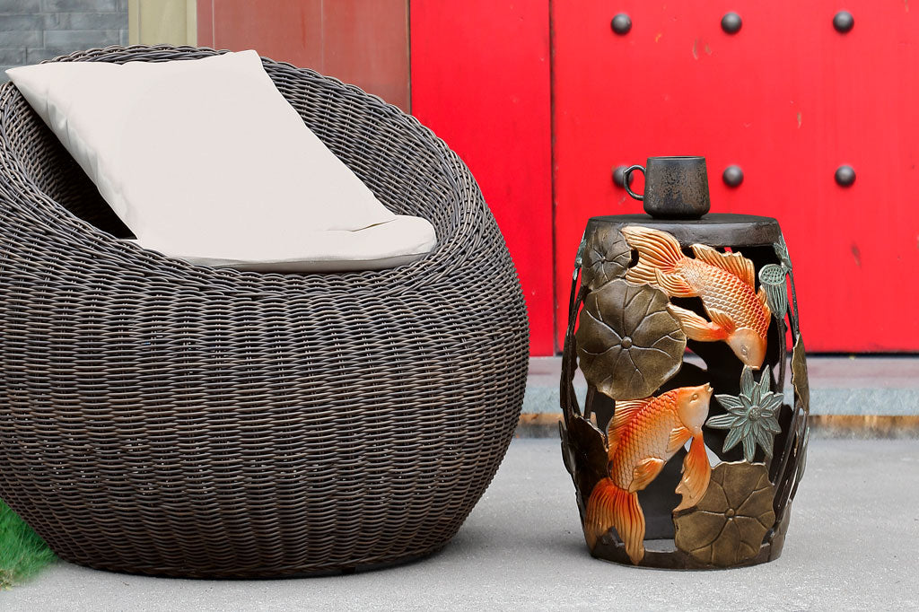 Cast Metal koi fish and water lily garden/ accent stool. Shown outdoors by big red door and wicker papasan chair.