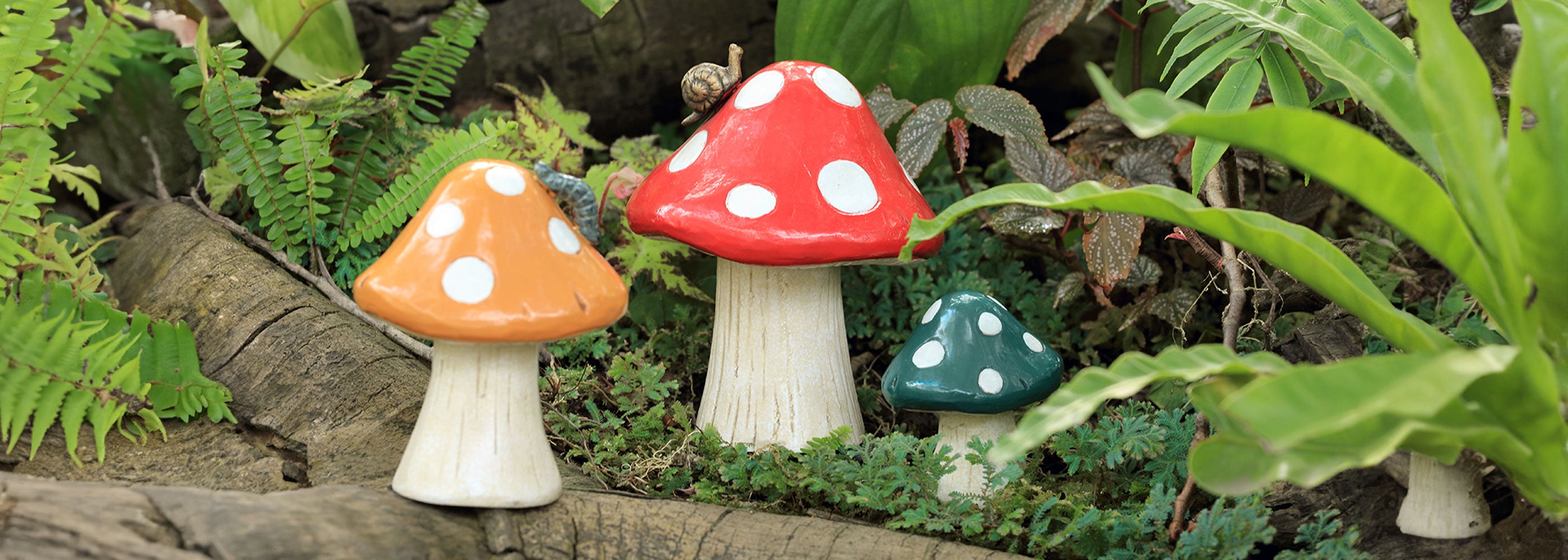 3 cast metal garden mushroom decor shown in tropical garden